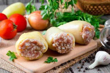 Pirinç ve et kesme tahtası üzerinde ham yeşil biber dolması