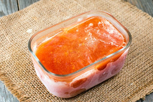 Frozen tomato juice in a glass container — Stock Photo, Image