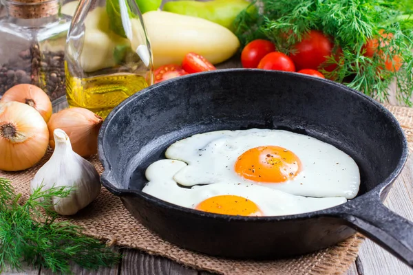 Huevos fritos en una sartén sobre un fondo negro —  Fotos de Stock