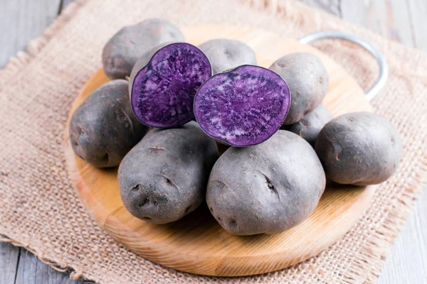 Ahşap bir masa üzerinde mor tatlı patates