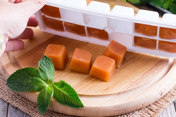 Cubos de fruta congelados en un cubo de hielo — Foto de Stock