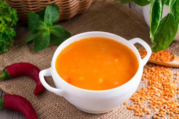 Ahşap arka plan üzerinde beyaz bir seramik kase mercimek çorbası