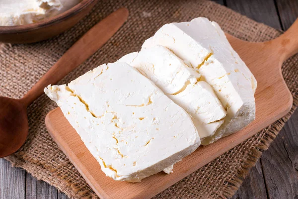 Кусочек свежего ржавого сыра на разделочной доске — стоковое фото