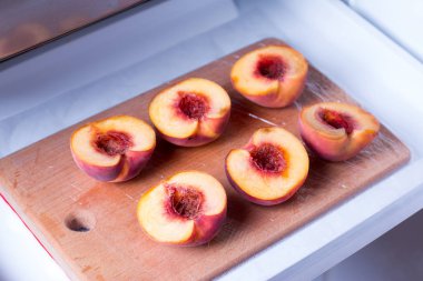 Bir dondurucu bir kesme tahtası üzerinde yarım şeftali