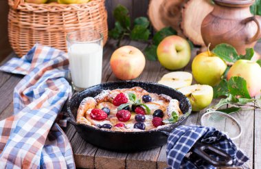 Hollandalı bebek gözleme ile elma ve tarçın eski bir ahşap masa arka plan üzerinde