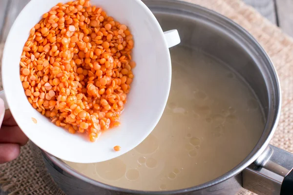 Подготовка красной чечевицы на сковороде — стоковое фото