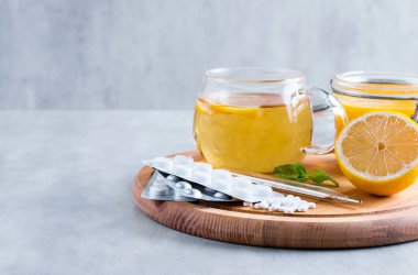 Öksürük için doğal maddeler üzerinde ahşap masa çare. Limon, tatlım, çay, nane ve tabletler. Üstten Görünüm, kopya için alan.