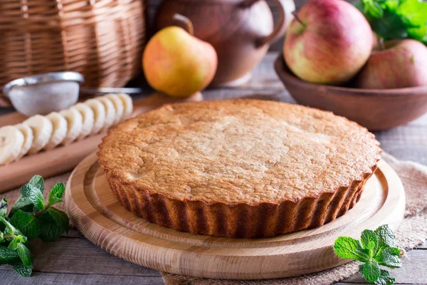 Pastries, cake with apples and a banana on a wooden background — Stock Photo, Image