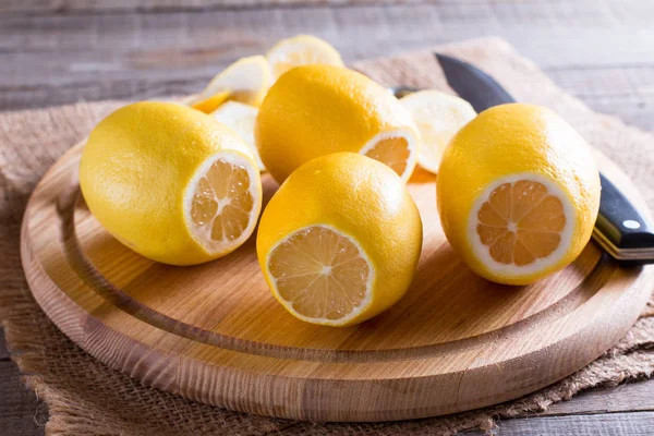 Cortar limón sobre tabla de cortar madera con fondo — Foto de Stock