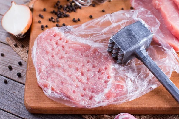 Свежая сырая свинина отбивает мясо в мешке на доске для рубки на деревянном столе — стоковое фото