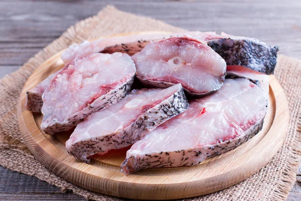 Куски сырой свежей рыбы на разделочной доске — стоковое фото