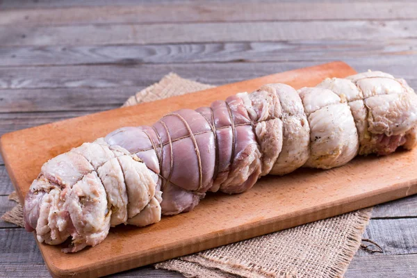 Raw roasted pork roll stuffed with vegetables and garlic — Stock Photo, Image