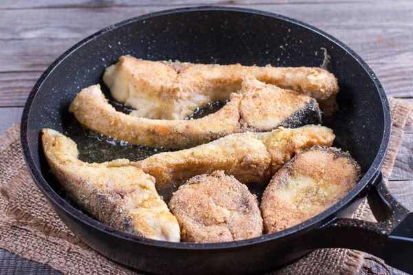 Fried fish snacks on frying pan. pieces of fried fish. pieces of fried fish in boiling oil. pieces of fried fish in hot oil in a frying pan — Stock Photo, Image