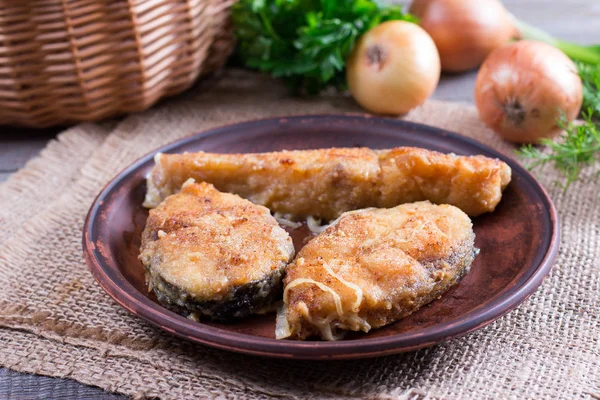 Fried fish on a plate on a wooden table — Stock Photo, Image
