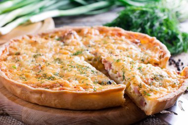 Quiche peynir ve domuz pastırması ile ahşap arka plan üzerine dilimlenmiş