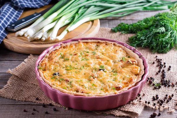 Quiche aus französischem Zwiebelkäse oder mit Petersilie bestreute Torte, mit Zutaten auf Schneidebrett — Stockfoto