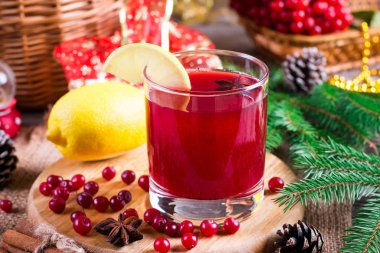 Ahşap arka plan üzerinde kızılcık içki süslü çam dalları, baharat ve taze çilek, seçici odak ile