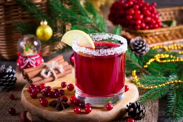 Праздничный клюквенный напиток на рождественском фоне с еловыми ветвями и свежими ягодами, избирательный акцент. Концепция праздника . — стоковое фото