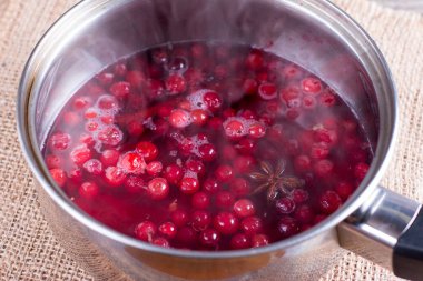 Kızılcık baharatlar ile sautepan içinde. Sıcak bir içecek