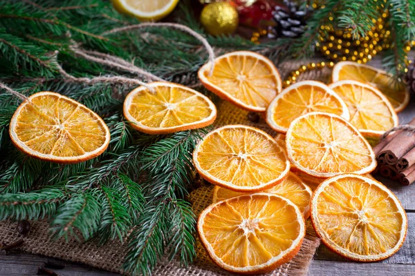 Noel ağacı kuru portakal, tarçın ve anason yıldız ahşap rustik masa ve arka planda köknar ağacı