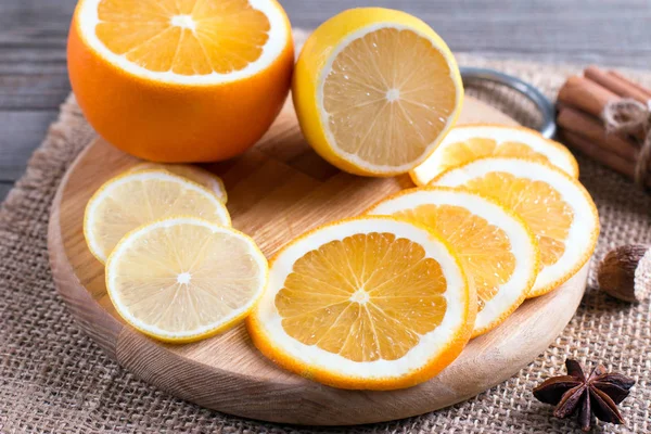 Rodajas de naranja y limón en una tabla de cortar — Foto de Stock