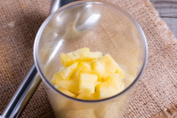 Ananas segmenten in een blender op tafel — Stockfoto