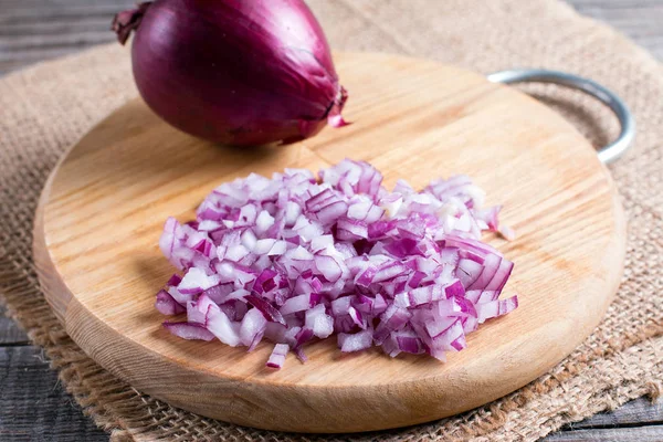 Bir kesme tahtası üzerinde kırmızı soğan dilimlenmiş