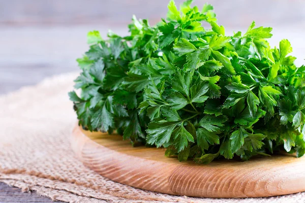 Demet yeşil ham taze maydanoz bir kesme tahtası üzerinde