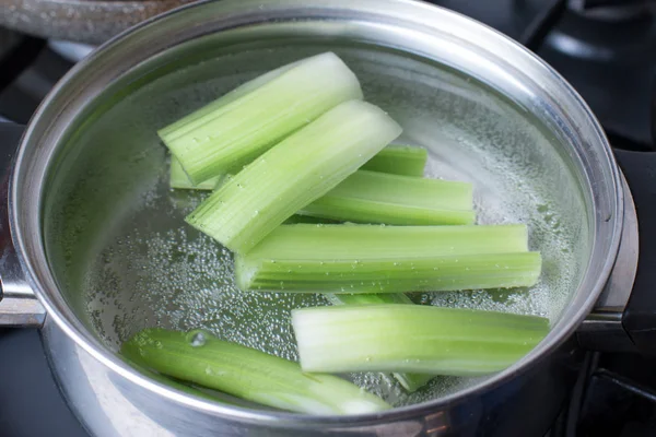 Stalks of celery in boiling water on the stove — Stock Photo, Image