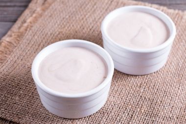 Ahşap bir masa beyaz seramik ortamda süzme peynir güveç