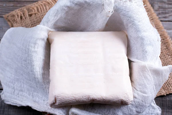 Замороженный йогурт в дуршлаге на деревянном столе — стоковое фото