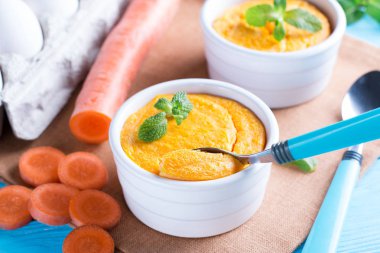 Kaşık ve lezzetli havuç sufle üzerinde ahşap masa ile güveç