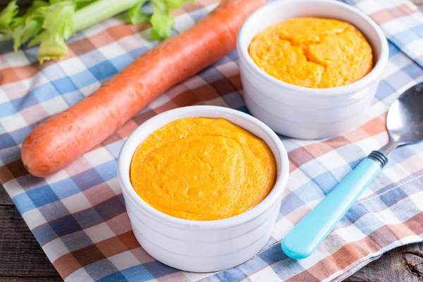 Ahşap masa üzerinde lezzetli havuç sufle ile güveç.