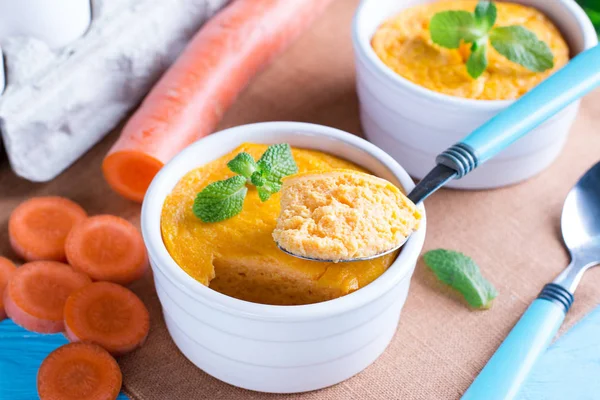 Kaşık ve lezzetli havuç sufle üzerinde ahşap masa ile güveç