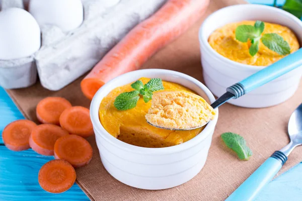 Kaşık ve lezzetli havuç sufle üzerinde ahşap masa ile güveç