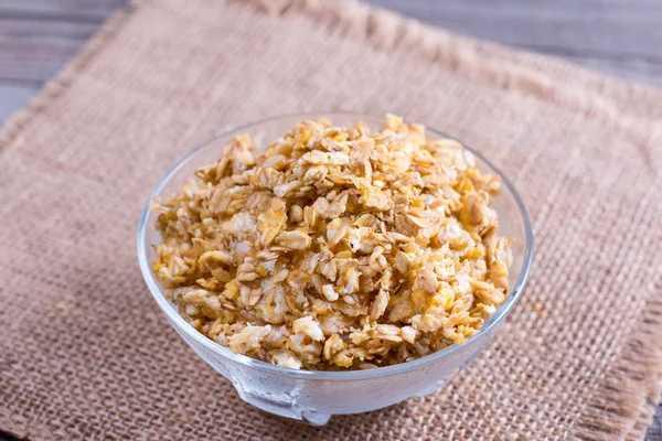 Granola em uma tigela de vidro em uma mesa de madeira — Fotografia de Stock