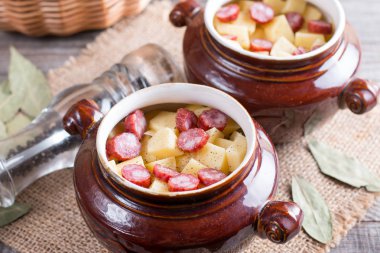 Pastırma ve eski ahşap masa ile seramik bir kasede servis Viyana sosis sıcak patates gulaş