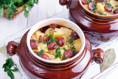 Pastırma ve bir tablo ile seramik bir kasede servis Viyana sosis sıcak patates gulaş