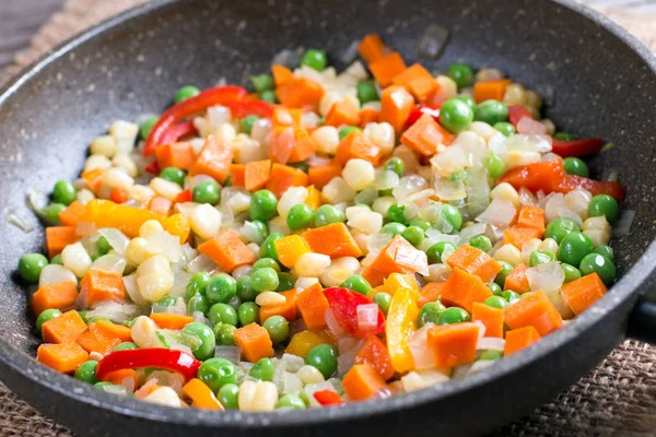 Mixed vegetables in a frying pan on wood table, Royalty Free Stock Images