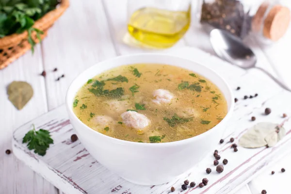 Sup dengan bakso ayam dan sayuran dengan latar belakang kayu putih — Stok Foto