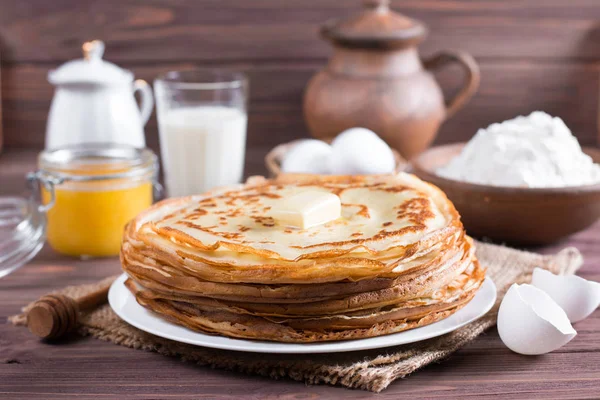 Viele Pfannkuchen auf einem hölzernen Hintergrund. traditionelle ukrainische oder russische Pfannkuchen. Fastnachtsmasleniza. — Stockfoto