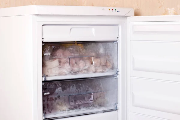 Assortment of frozen meat and dumplings in home fridge. Frozen food in the refrigerator.