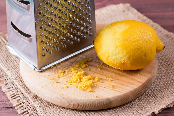 Grater peel and lemon zest on the wooden table — Stock Photo, Image