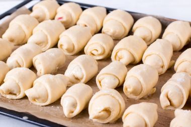 Mutfakta bir fırın tepsisine küçük ev yapımı kruvasan yapma