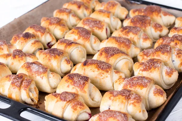 Piccoli croissant dolci fatti in casa in cucina su una teglia — Foto Stock