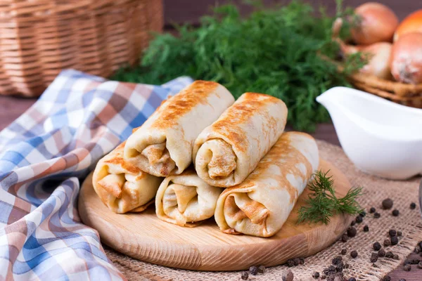 Crepes rellenos de carne picada y arroz en una tabla de cortar sobre una mesa de madera — Foto de Stock