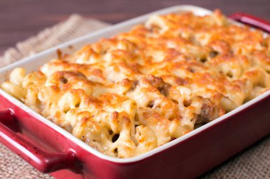 Seramik form arka plan ahşap masa üzerinde pişmiş peynirli makarna