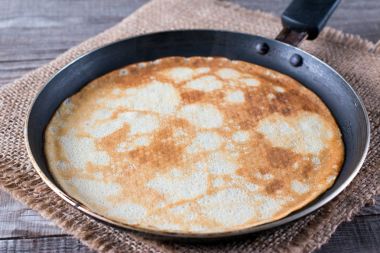 Ahşap masa üzerinde lezzetli ince krep tava