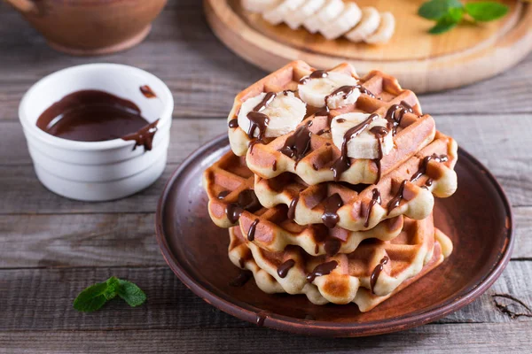 Çikolata sosu ve muz dilimi bir plaka üzerinde ev yapımı Belçika waffle — Stok fotoğraf