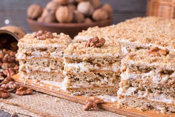 Läcker honung kaka med söta gräddfil och nötter på en rustik bakgrund — Stockfoto